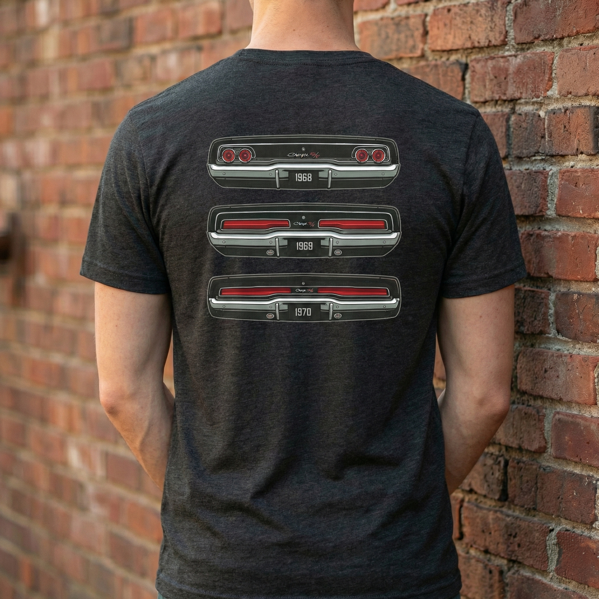 Person wearing a black t-shirt with car grille design on the back, standing against a brick wall.